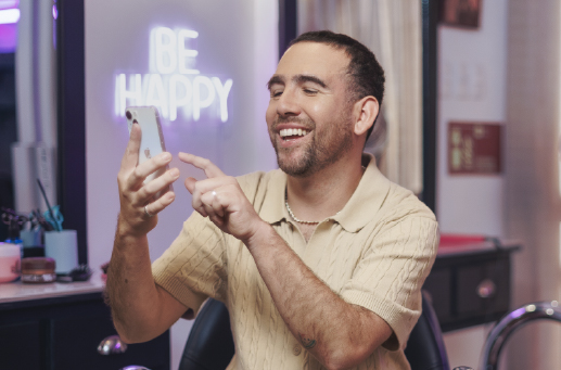 Hombre sonriente señala la pantalla en campaña de Achs Seguro Laboral para empresas y pymes con dos o más trabajadores.